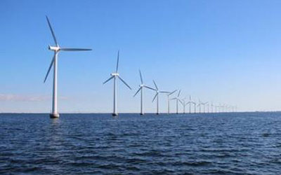 平靜的海面上佇立著一排風(fēng)力發(fā)電機，體現(xiàn)永磁材料在風(fēng)力發(fā)電領(lǐng)域的應(yīng)用